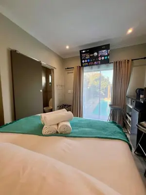 a bedroom with a bed with two towels on it at Tehillah on Boom in Bothasig