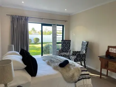 a bedroom with a large bed with a large window at The Nook in Stellenbosch