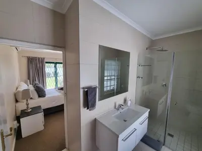 a white bathroom with a sink and a shower at The Nook in Stellenbosch