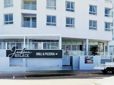 a building with a black and white sign on it at Sunset Accommodation in Strand in Strand