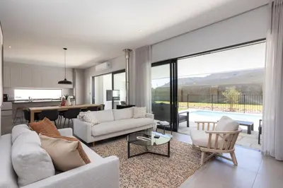 a living room with white furniture and a large window at Luxury Villa 712 Pearl Valley Golf Estate in Paarl