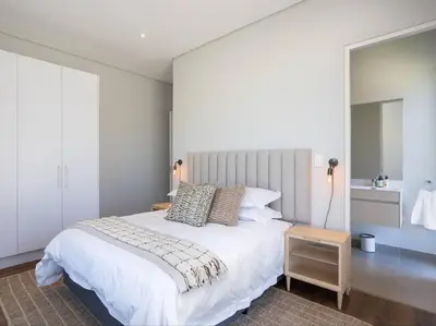a bedroom with a large white bed and a table at Luxury Villa 712 Pearl Valley Golf Estate in Paarl