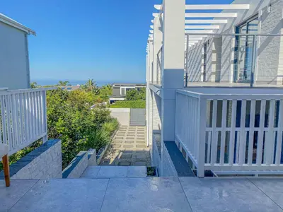 a stairway leading up to a house with a balcony at Chanteclair Re-Energised 1 Bed 1 Bath in Hermanus