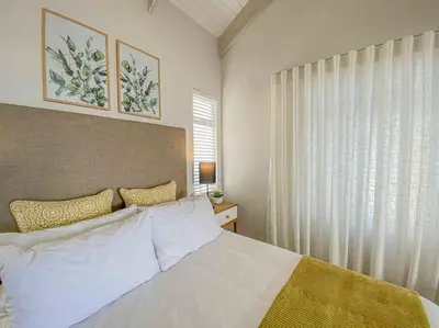 a bedroom with a white bed and a window at Chanteclair Re-Energised 1 Bed 1 Bath in Hermanus
