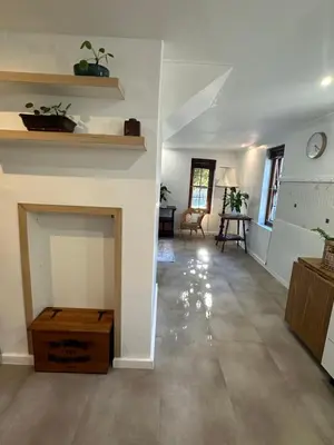 a living room with white walls and a fireplace at Koetshuis on High Street in Paarl