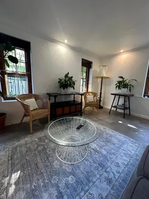 a living room with a glass table and chairs at Koetshuis on High Street in Paarl