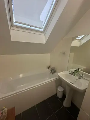a bathroom with a sink and a bath tub and a window at Koetshuis on High Street in Paarl