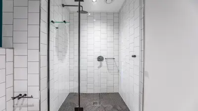 a bathroom with a shower with white tiles at Little island in Cape Town