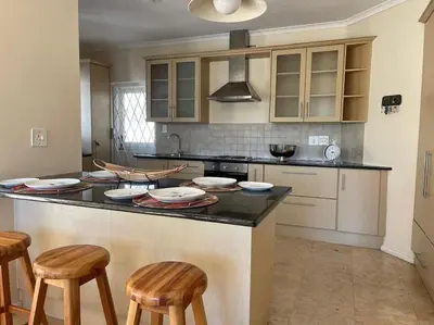 a kitchen with a counter with stools in it at Paradyskloof home in Stellenbosch