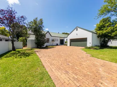 a brick driveway in front of a white house at Paradyskloof home in Stellenbosch