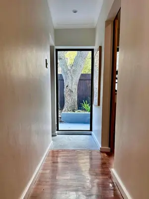 an empty hallway with a door with a tree outside at Die Klein Huis in Cape Town