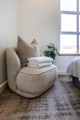 a living room with a chair with pillows on it at Lush garden 3 bedroom house in Franschhoek