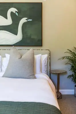 a bedroom with a bed and a painting of swans at Lush garden 3 bedroom house in Franschhoek