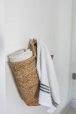 a basket with a towel hanging on a wall at Lush garden 3 bedroom house in Franschhoek