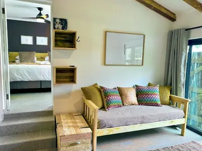 a living room with a couch and a bed at Amsterdam Suite in Cape Town
