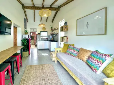 a living room with a couch and a kitchen at Amsterdam Suite in Cape Town