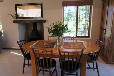 a wooden dining room table with chairs and a mirror at Hidden gem in bush 350m from main beach in Bettyʼs Bay
