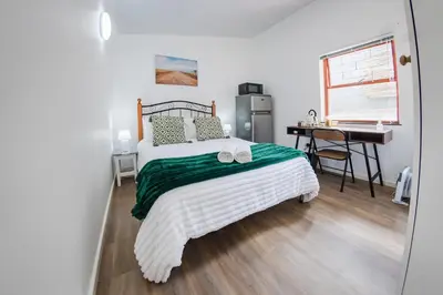 a bedroom with a bed and a desk in it at Modern & Central 1 BR Apt Close To Major Attractions in Cape Town