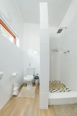 a white bathroom with a toilet and a shower at Modern & Central 1 BR Apt Close To Major Attractions in Cape Town