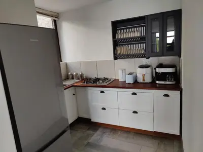 a kitchen with white cabinets and a counter top at Gordon's Bay Sunset View in Cape Town