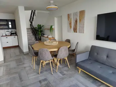 a dining room with a table and chairs and a couch at Gordon's Bay Sunset View in Cape Town