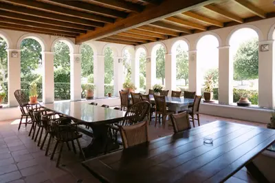 a dining room with tables and chairs and windows at Manor House at La Roche Estate - Franschhoek in Franschhoek