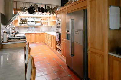 a kitchen with wooden cabinets and a stainless steel refrigerator at Manor House at La Roche Estate - Franschhoek in Franschhoek