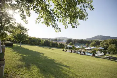 a view of a lawn with tables and umbrellas at Cultivar Boutique Hotel in Stellenbosch