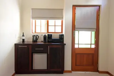 a room with a table with a microwave and a door at Cultivar Boutique Hotel in Stellenbosch