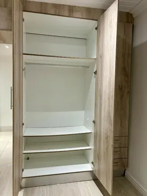 a closet with white shelves and a wooden door at Garden Flat in Cape Town