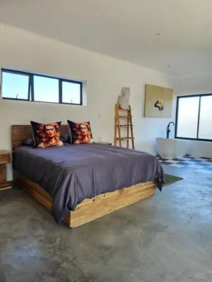 a bedroom with a large bed and a bath tub at MAGNIFICENT 6 sleeper mountain getaway in Romansrivier