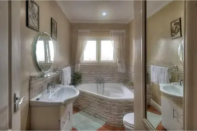 a bathroom with two sinks and a tub and a toilet at TUSCAN VILLA FELICE near West Coast in Cape Town