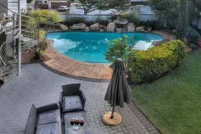 an overhead view of a swimming pool with an umbrella at TUSCAN VILLA FELICE near West Coast in Cape Town