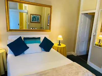 a bedroom with a bed with a large mirror at Mill House Bed and Breakfast in Stellenbosch