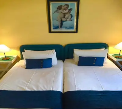 a bedroom with two beds with blue and white pillows at Mill House Bed and Breakfast in Stellenbosch