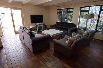 a living room with two couches and a table at Somerset West Family home holiday rental in Cape Town