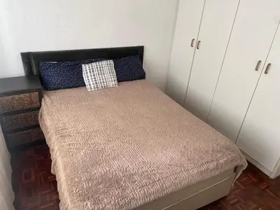 a small bed in a room with white cabinets at House on Gill 2 in Cape Town