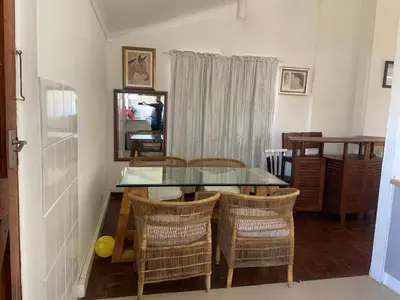 a dining room with a glass table and chairs at House on Gill 2 in Cape Town