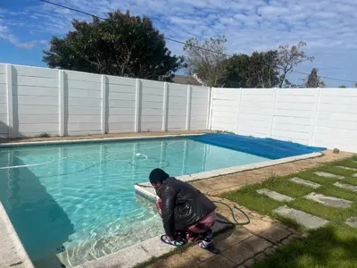 a person standing next to a pool with a hose at House On Gill 3 in Cape Town