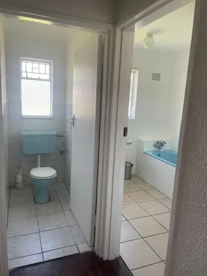 a bathroom with a blue toilet and a tub at House On Gill 3 in Cape Town