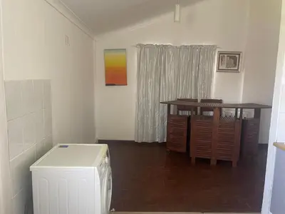 a living room with a table and a desk and aicter at House On Gill 3 in Cape Town