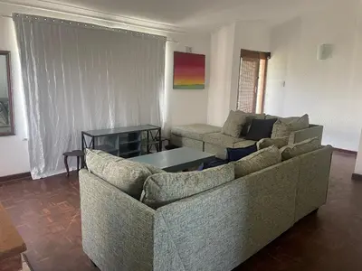 a living room with two couches and a table at House On Gill 3 in Cape Town