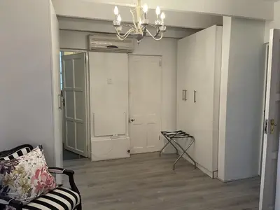 a living room with a chandelier and a couch at Franschhoek Wine Tram Apartment in Franschhoek