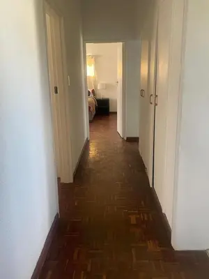 a hallway with a long hallway with a floor of wood at House on Gill 25 in Cape Town
