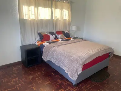 a bedroom with a bed and a television in it at House on Gill 25 in Cape Town