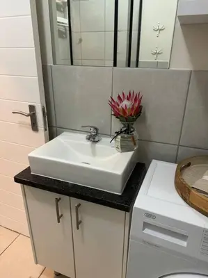 a bathroom with a white sink and a mirror at Slaap Self Catering in Paarl