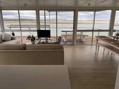 a living room with a couch and a table with a television at Moonshine in Hermanus