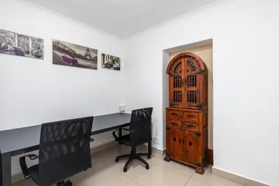 a home office with a desk and two chairs at Ina se Huisie in Blouberg self Catering Apartment in Cape Town