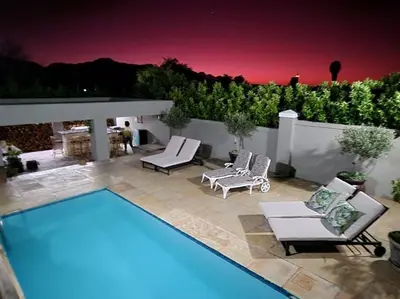 a swimming pool with two lounge chairs and avisor at C'est la Vie 4 in Franschhoek
