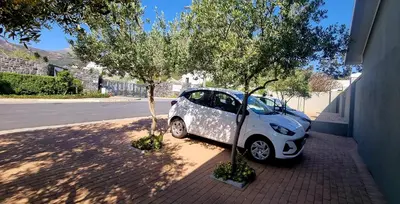 a small white car parked next to a tree at C'est la Vie 4 in Franschhoek